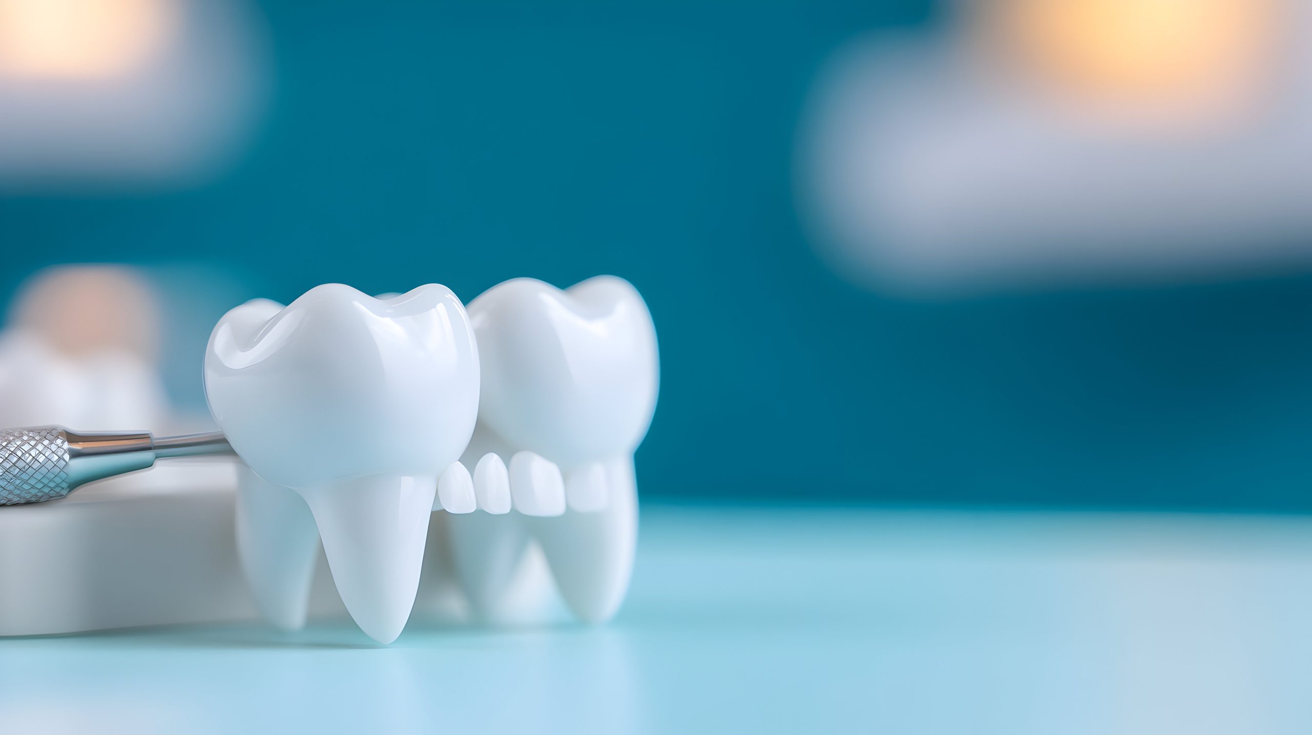 Closeup of White Teeth Model with Dental Instrument on Teal Background